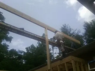 Carpenter setting a ridge beam over a new addition frame — Ice Dam Removal by Roofing Brothers in Coopersburg