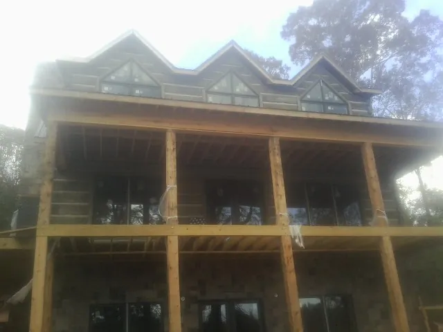 Dormers and porch framing on a large log home under construction — Roof Coating work by our crew in Coopersburg