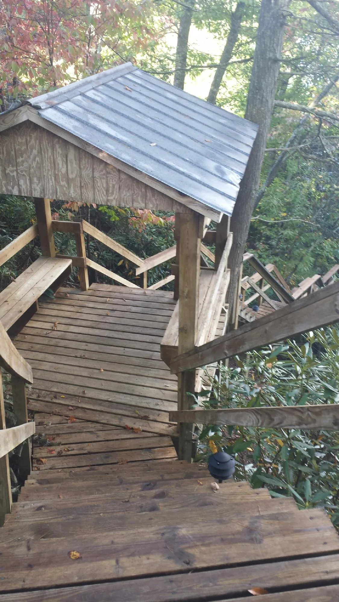 Metal roofed shelter over wooden steps on a wooded walkway — Skylight Repair & Installation work by our crew in Coopersburg